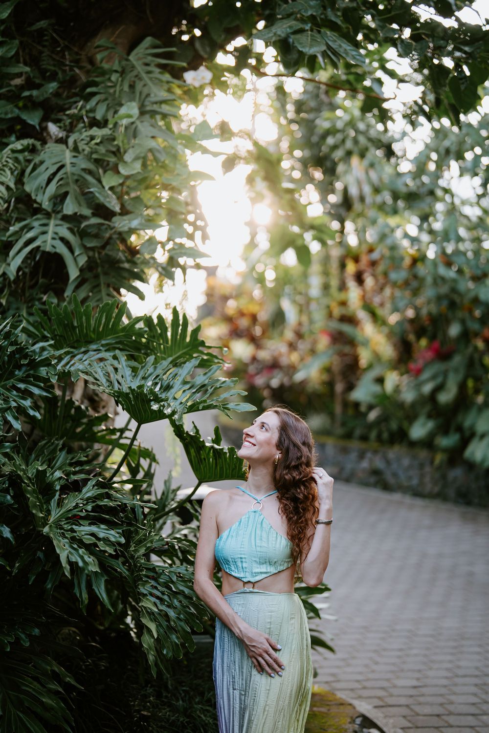 Dreamy garden photoshoot with soft bokeh lights and tropical plants.