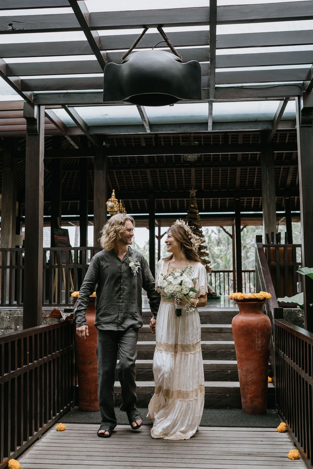 Couple walks along modern covered walkway with terra cotta planters.