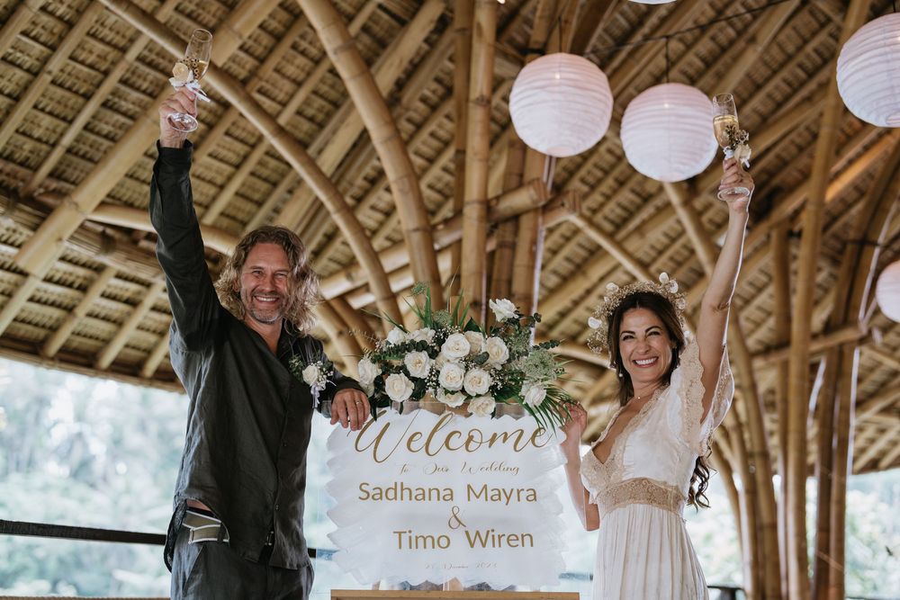 A rustic bamboo wedding venue decorated with white paper lanterns and welcome signs.