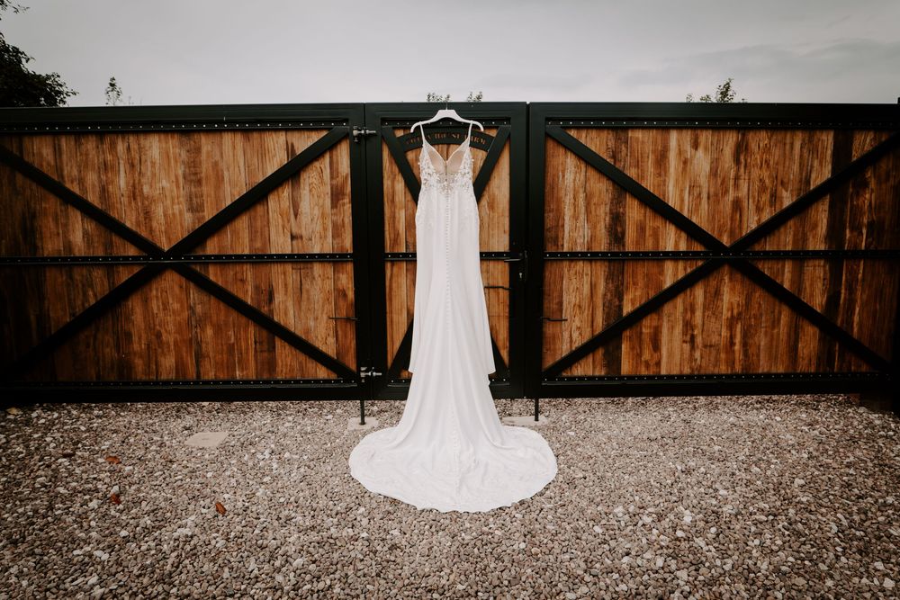 White wedding dress displayed on wooden barn doors.