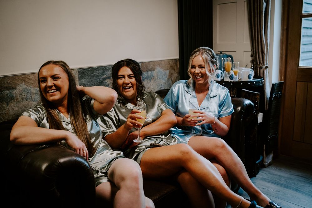 Wedding party members relaxing and laughing together indoors.