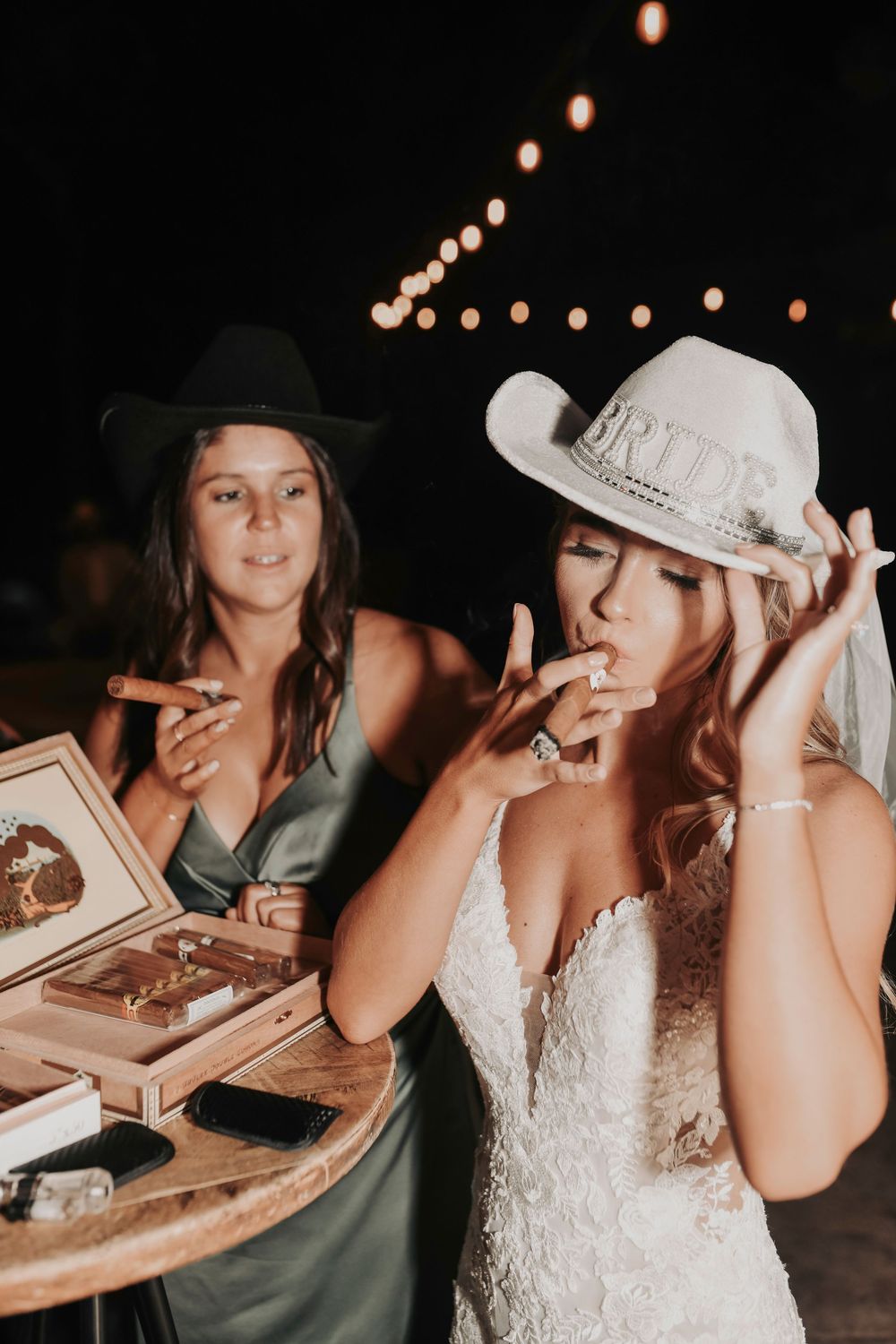 the bride candidly tokes on a cigar at her wedding reception