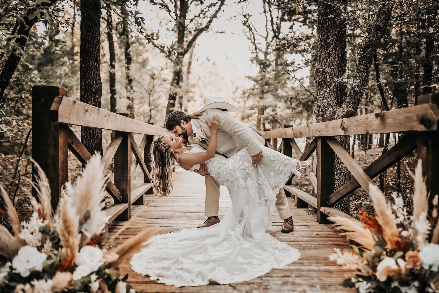 the most epic dip between a groom wearing a cowboy hat and his elegant bride
