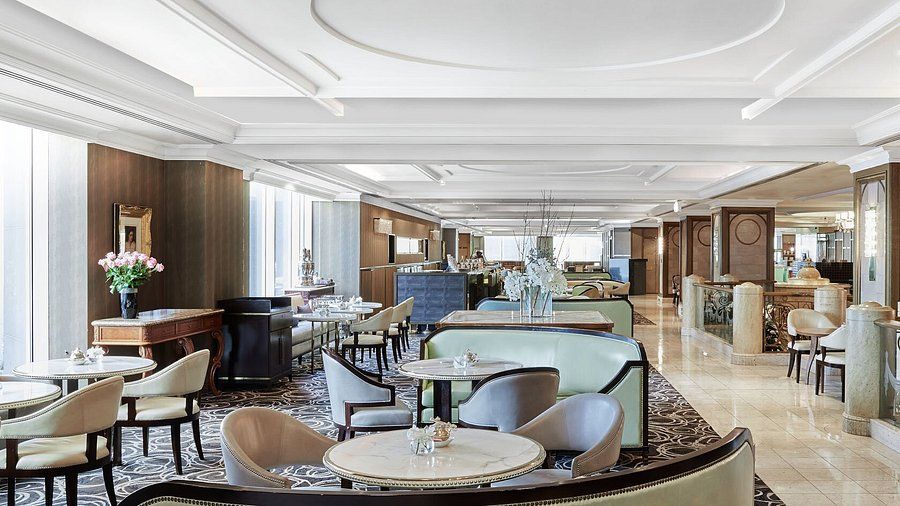Modern hotel lounge interior with luxurious white seating, contemporary decor, and elegant lighting fixtures.