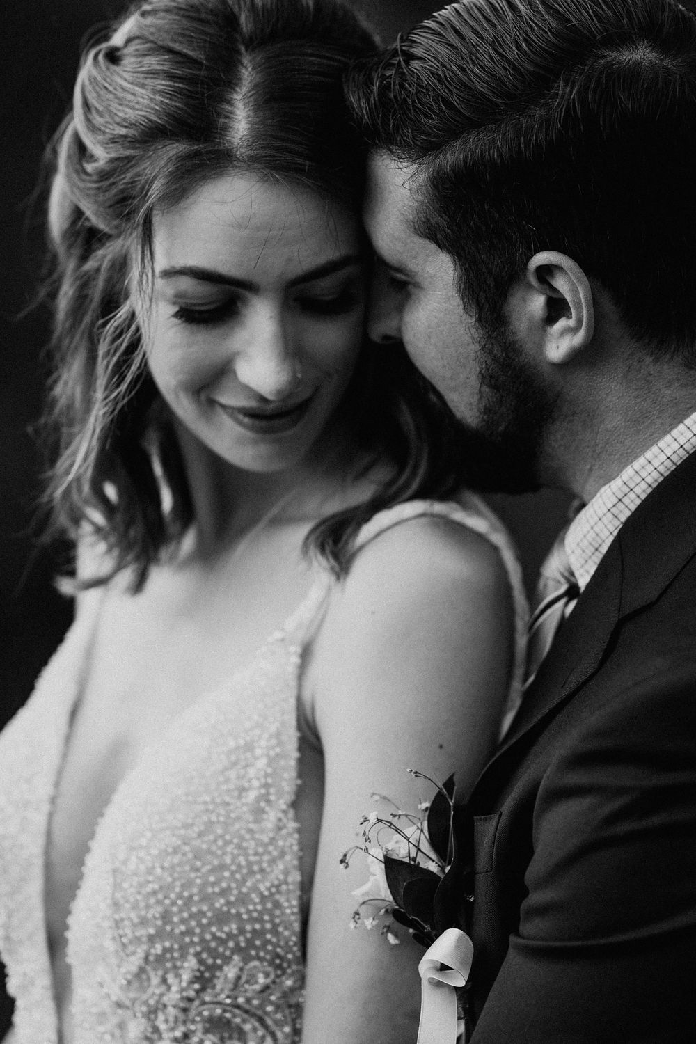 Close-up wedding photos showing tender moments between a couple in formal attire.