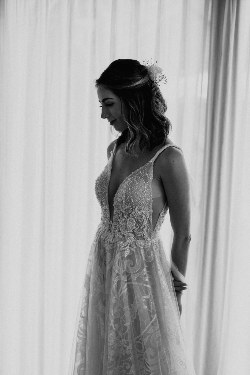 Artistic black and white photos of a wedding dress with intricate lace details.