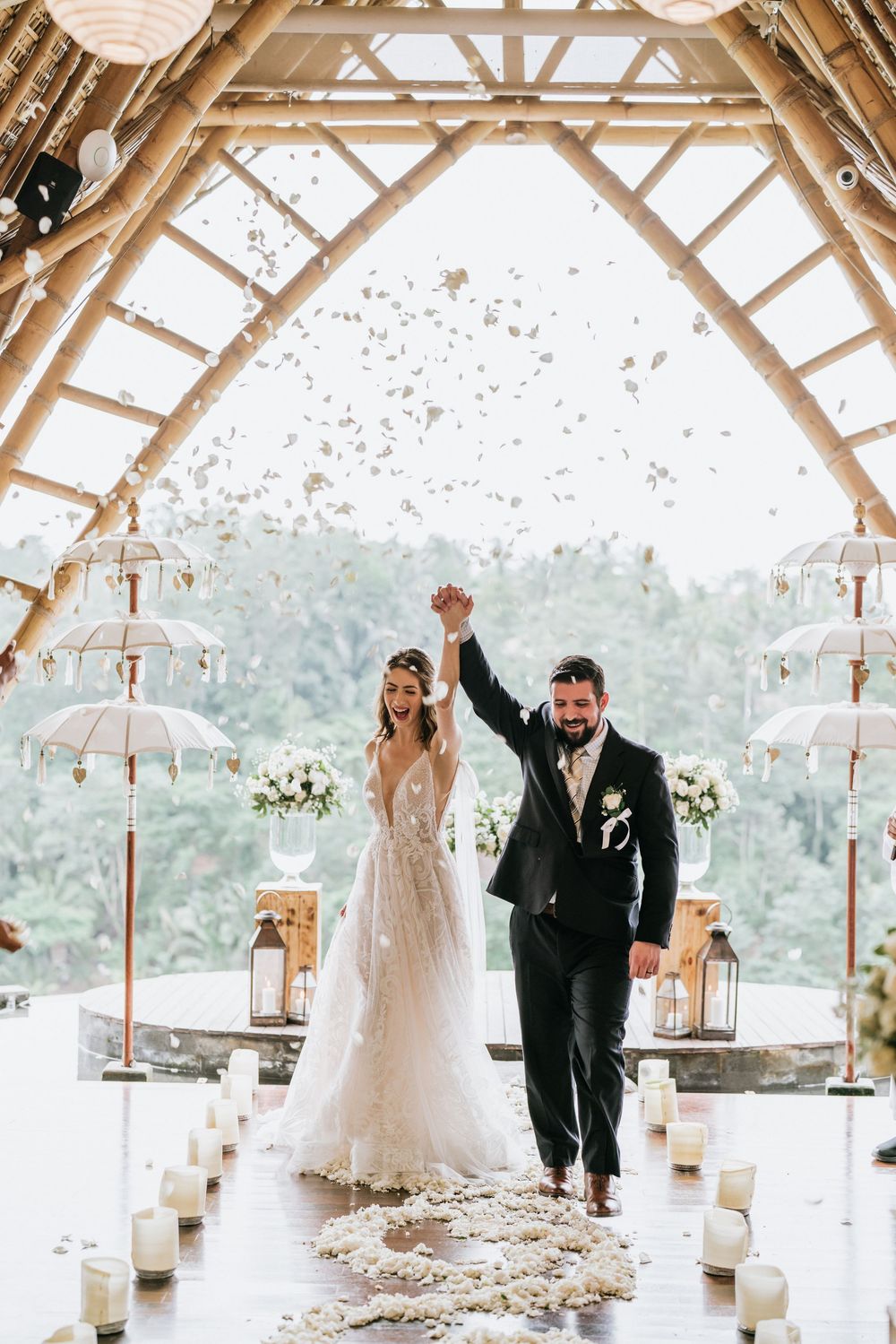 Wedding celebration in an open-air pavilion decorated with lanterns and floral arrangements.