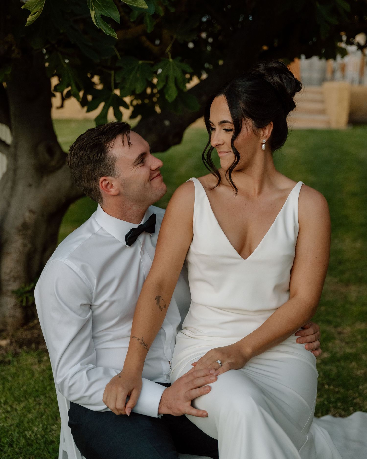 Intimate wedding couple portrait captured in a garden setting with natural sunlight.