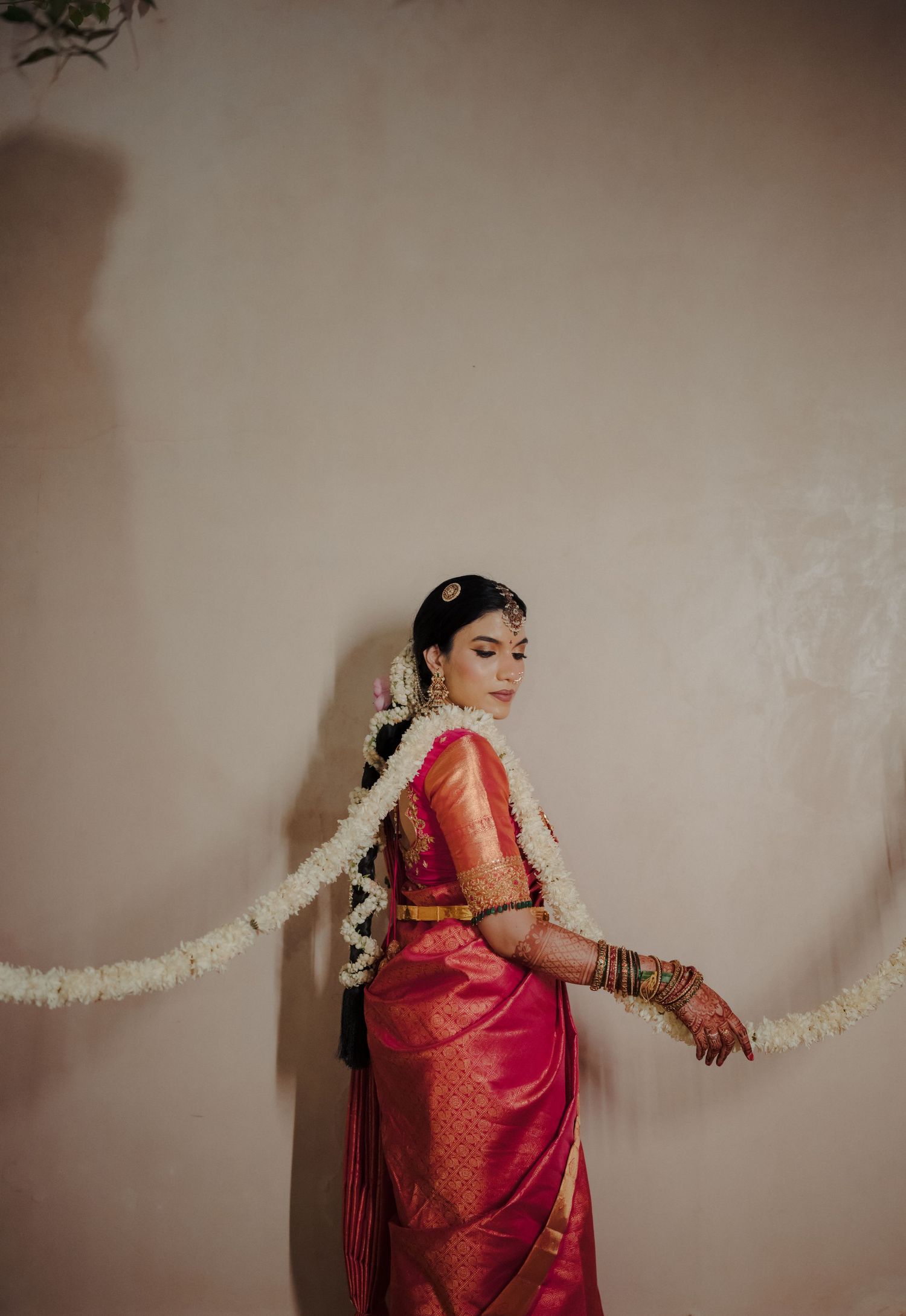 Traditional bridal portrait with flowing veil against neutral backdrop and soft lighting.