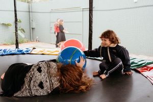 A sequence of five people sleeping in various poses during a performance piece at an art installation.