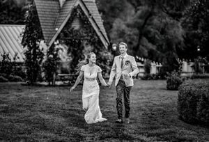 A sequence of seven black and white photos showing a couple running and twirling together in a garden setting.