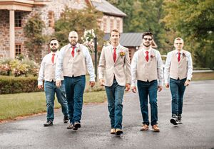 Five figures in white suits and blue jeans walk together down a path in a playful sequence of wedding party photos.