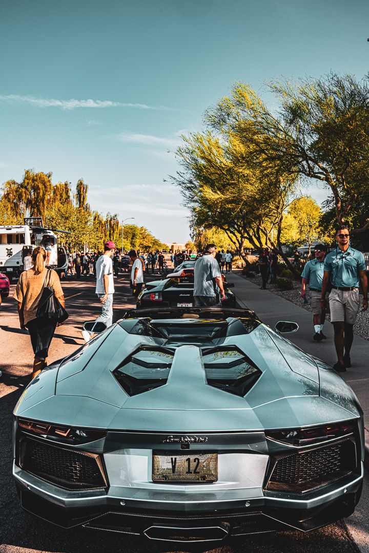 A silver high-performance Lamborghini Aventador convertible supercar photographed from multiple angles at a luxury car event.