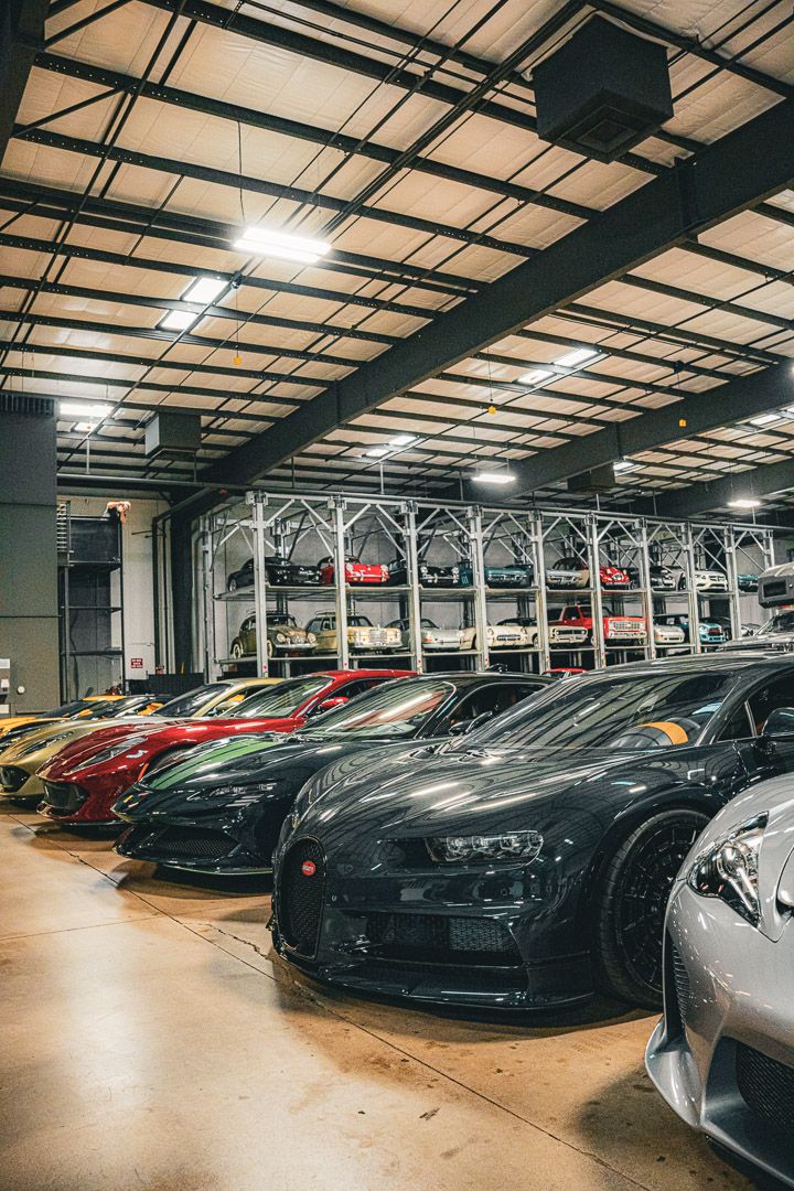 Luxury car collection featuring multiple supercars arranged in a climate-controlled storage facility.