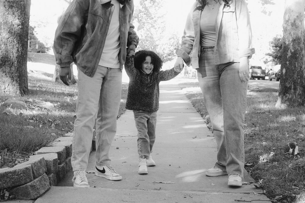 A black and white photo of people's legs and feet walking on a sidewalk or path.
