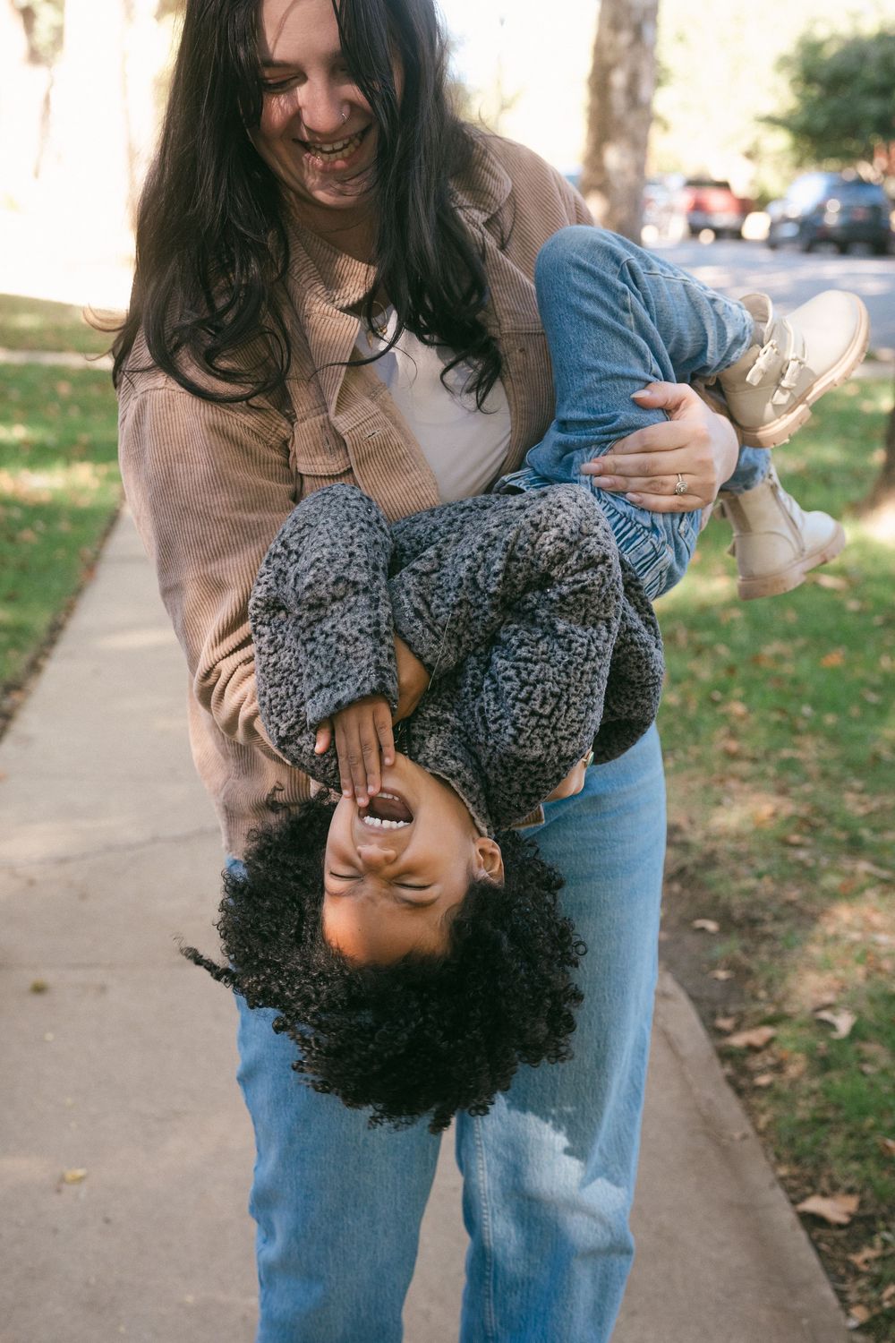 A playful moment captured in a sequence showing someone being dipped backwards on a sidewalk with fallen autumn leaves.