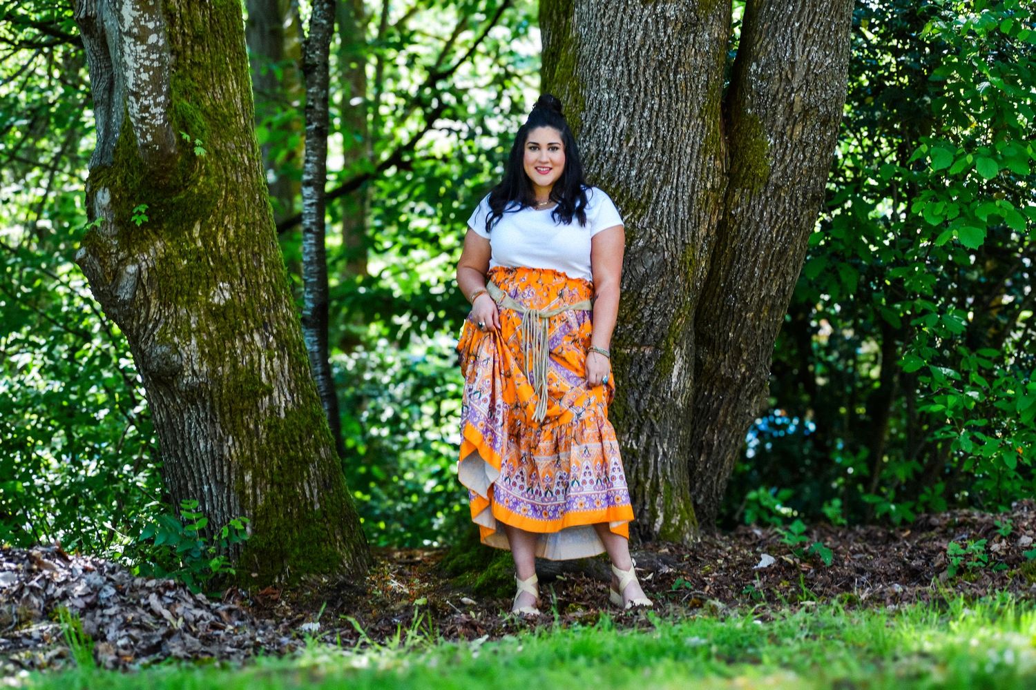 Woman walking through a vibrant field of wildflowers in a floral skirt, captured mid-movement under a bright blue sky. Seattle, WA