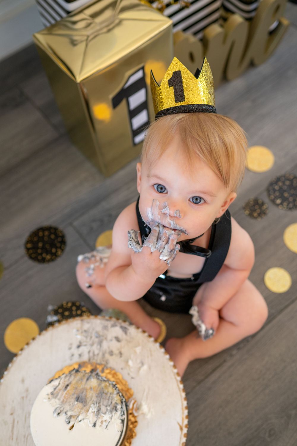First birthday cake smash scene with gold crown and decorative party setup. Cake smash