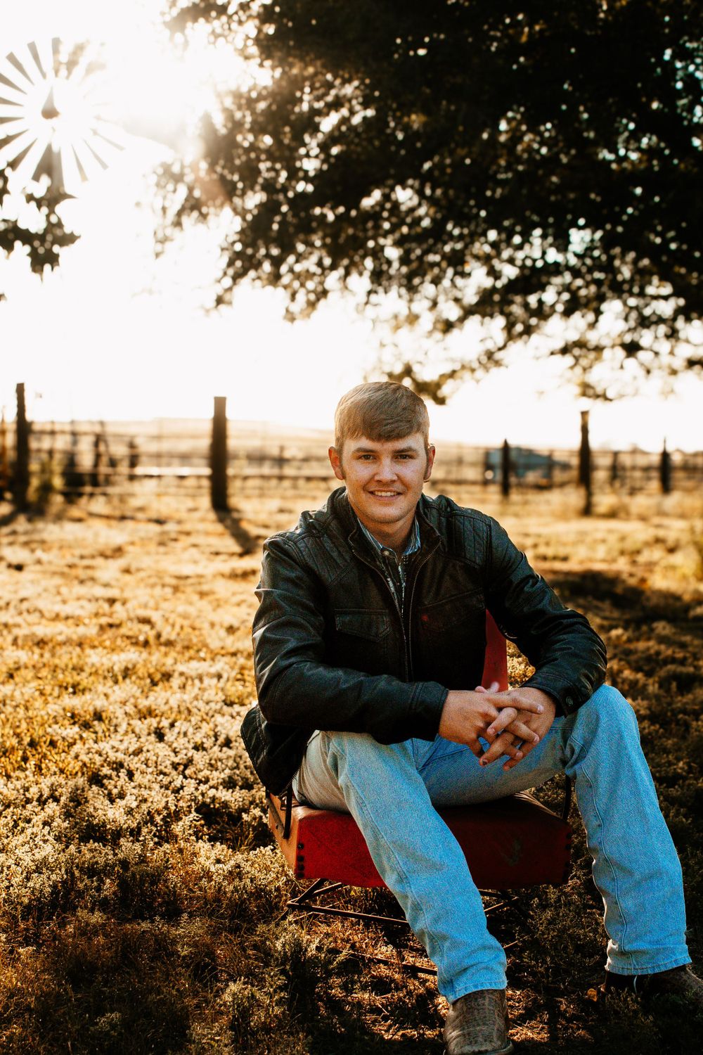 A ranch portrait with a windmill silhouette in the golden sunset background.