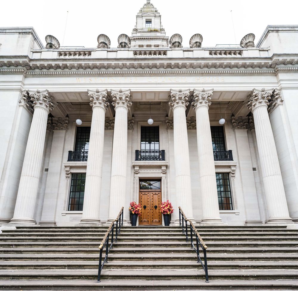 Classical courthouse building with white Corinthian columns and grand stone steps leading to wooden double doors.