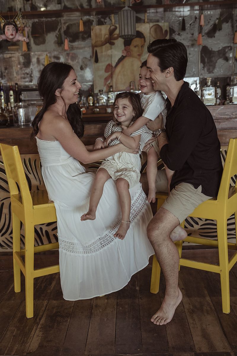 Parents laughing with daughter during a luxury family photoshoot at La Zebra Hotel in Tulum, Riviera Maya.