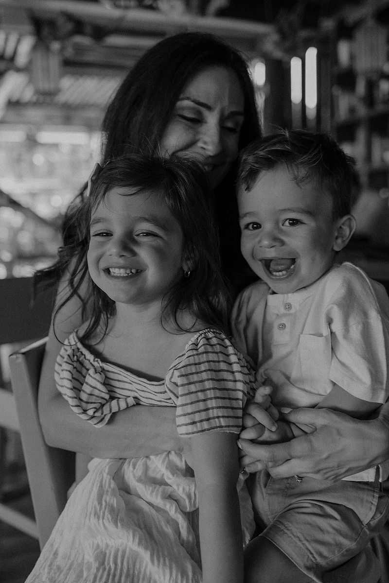 Mother holding children close in an intimate family portrait at La Zebra Hotel, Tulum.