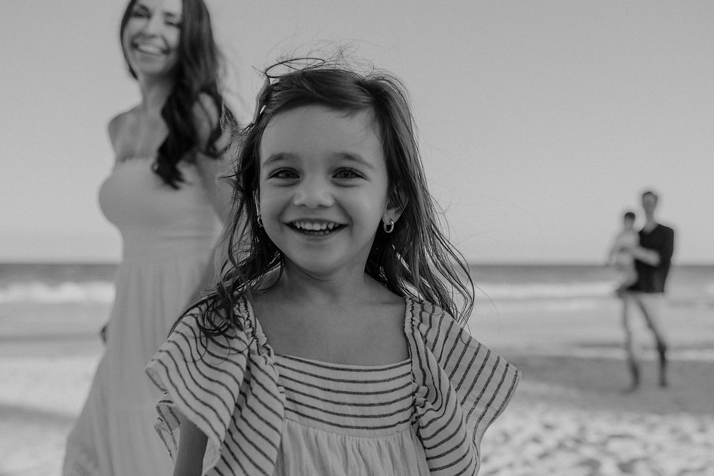 Sequence of black and white beach portraits showing carefree moments and genuine smiles by the ocean at La Zebra Hotel.