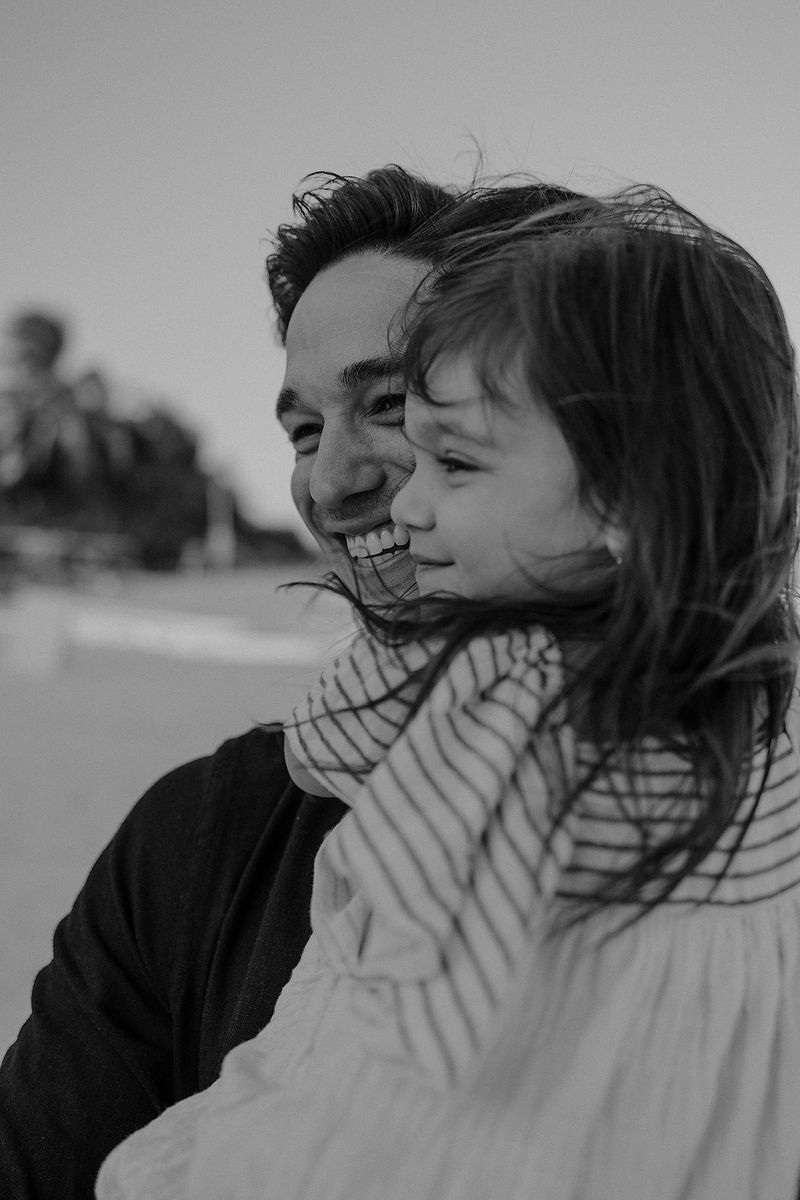 Black and white portrait of father smiling with daughter during Tulum family photoshoot.
