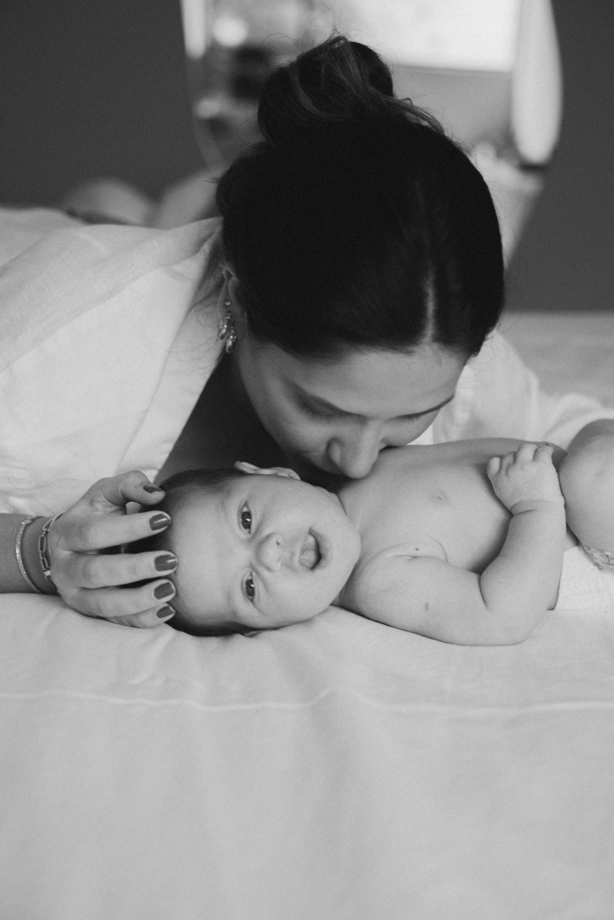 Intimate black and white portrait of tender moment with newborn baby.