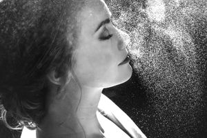 Prachtige closeup van bruid die settingspray op krijgt nadat haar make-up gedaan is tijdens de getting ready voor hun trouwdag.