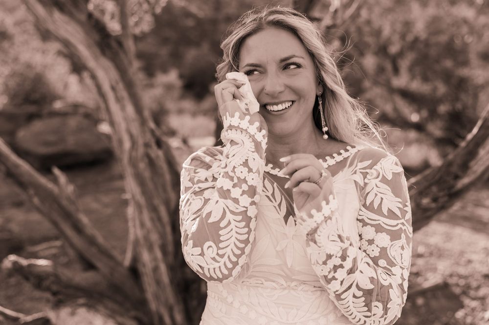 Black and white portrait capturing joyful wedding moment in Sedona desert setting.