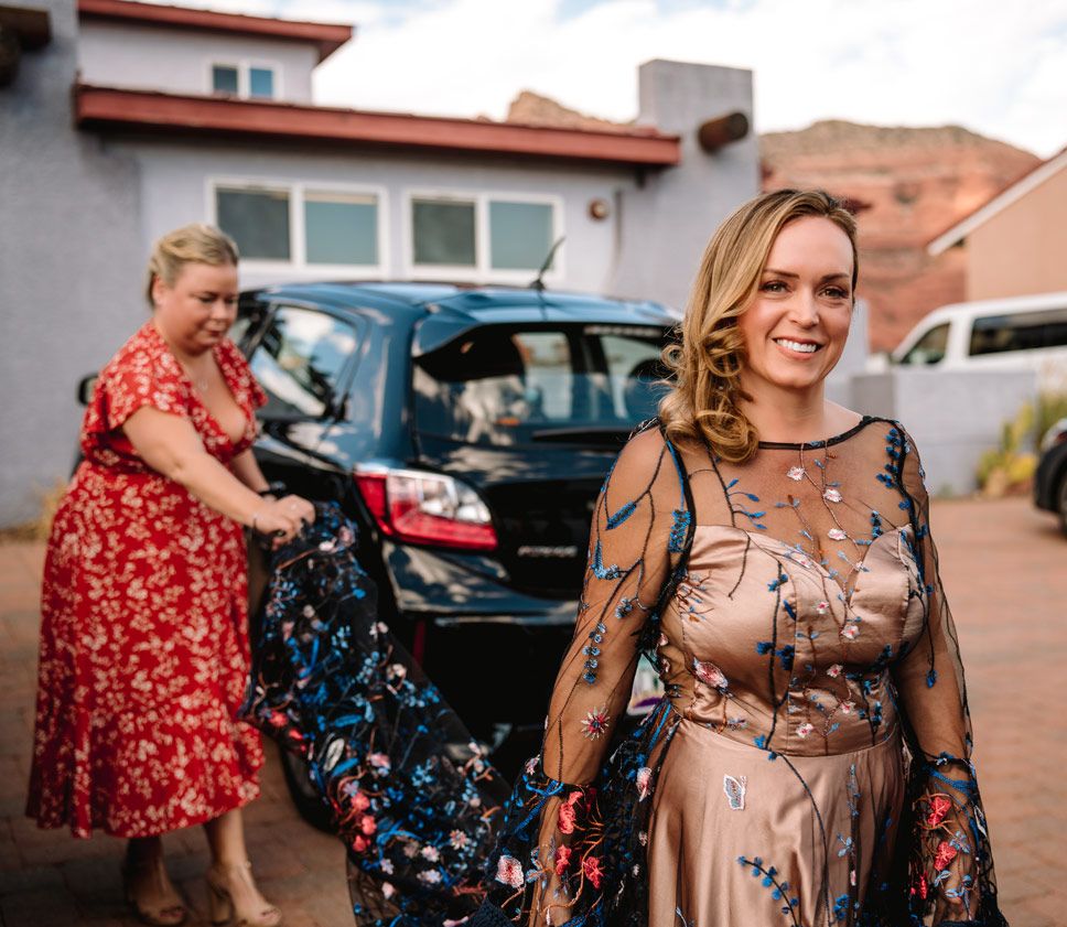 Wedding preparations take place in a parking lot with Sedona red rock formations visible in the background.