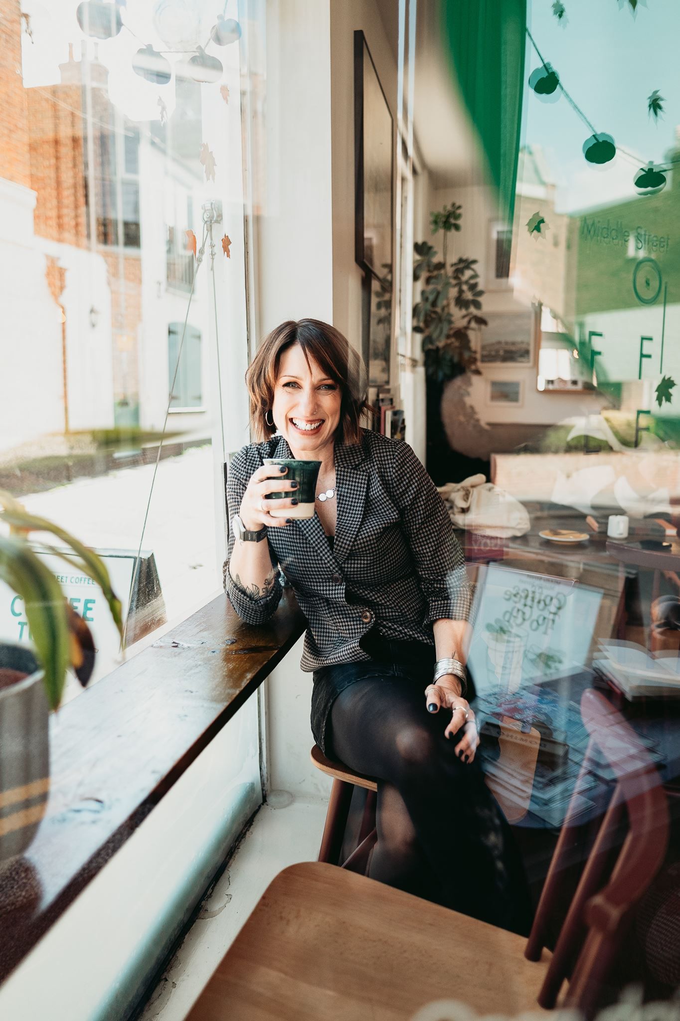 Branding Photographer Laura Sutcliffe Laura Sutcliffe, brand photographer, laughing in a coffee shop window