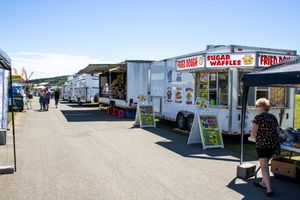 Row of food vendor trailers and concession stands at an outdoor festival.