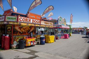 Carnival food vendors and concession stands line a festival walkway.