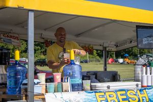 Yellow food vendor tent with FRESH signage at an outdoor event.