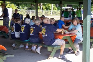 People gathered under a covered pavilion at an outdoor community event.