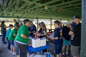Long covered pavilion filled with people during a daytime outdoor event.