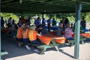 Covered outdoor shelter filled with people during a community gathering.