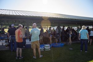 Panoramic view of outdoor pavilions with people gathering during a sunny day.
