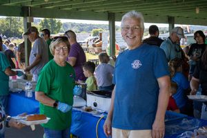 People gathered under a covered pavilion area during a community event.