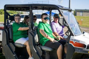 Group of participants seated in golf carts during an outdoor event.