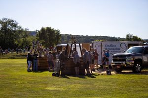 Outdoor event setup with multiple vendor trailers and tents spread across a field.