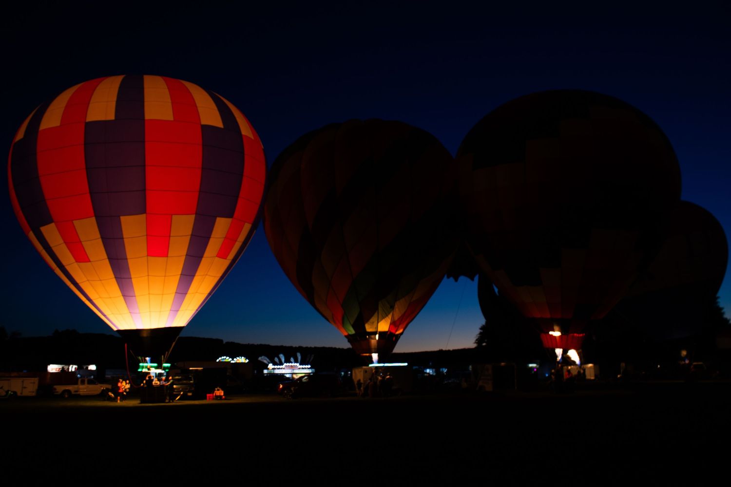 Hot air balloons illuminated at night creating a spectacular light display.