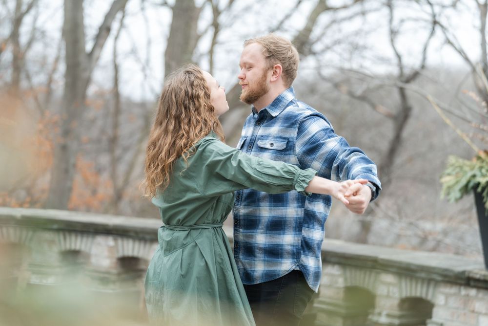 Fiancé spinning his bride-to-be during their engagement session, with laughter and sunlight all around