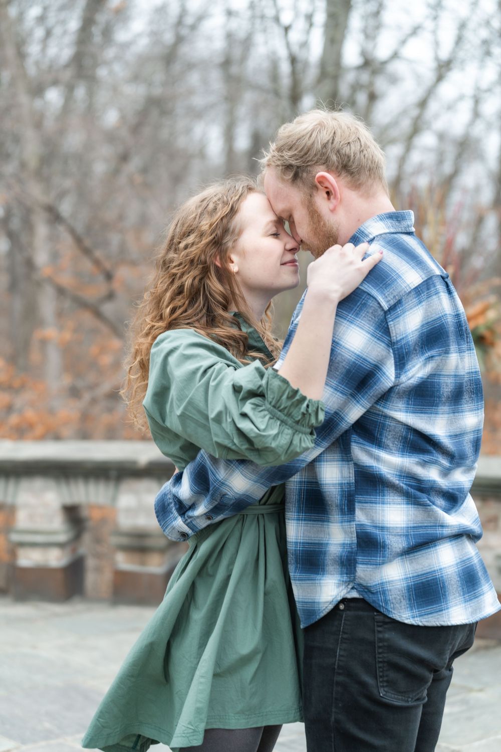 Couple nestled on a garden balcony sharing a quiet moment during their nature-filled engagement session