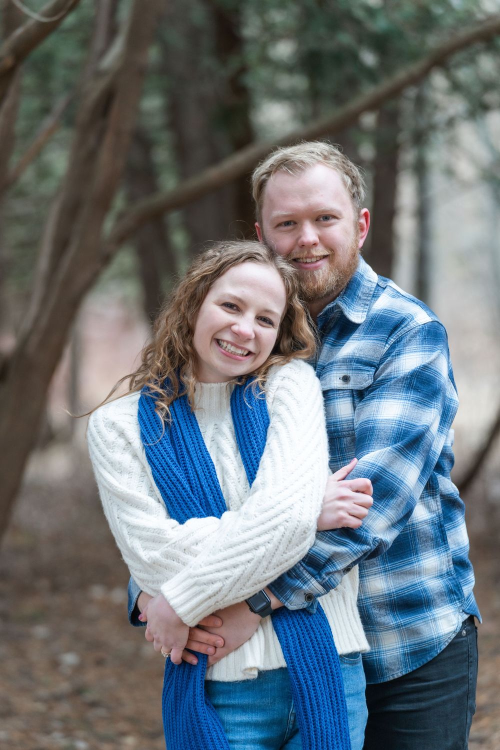 Tender moment between an engaged couple standing close under soft natural light at the arboretum
