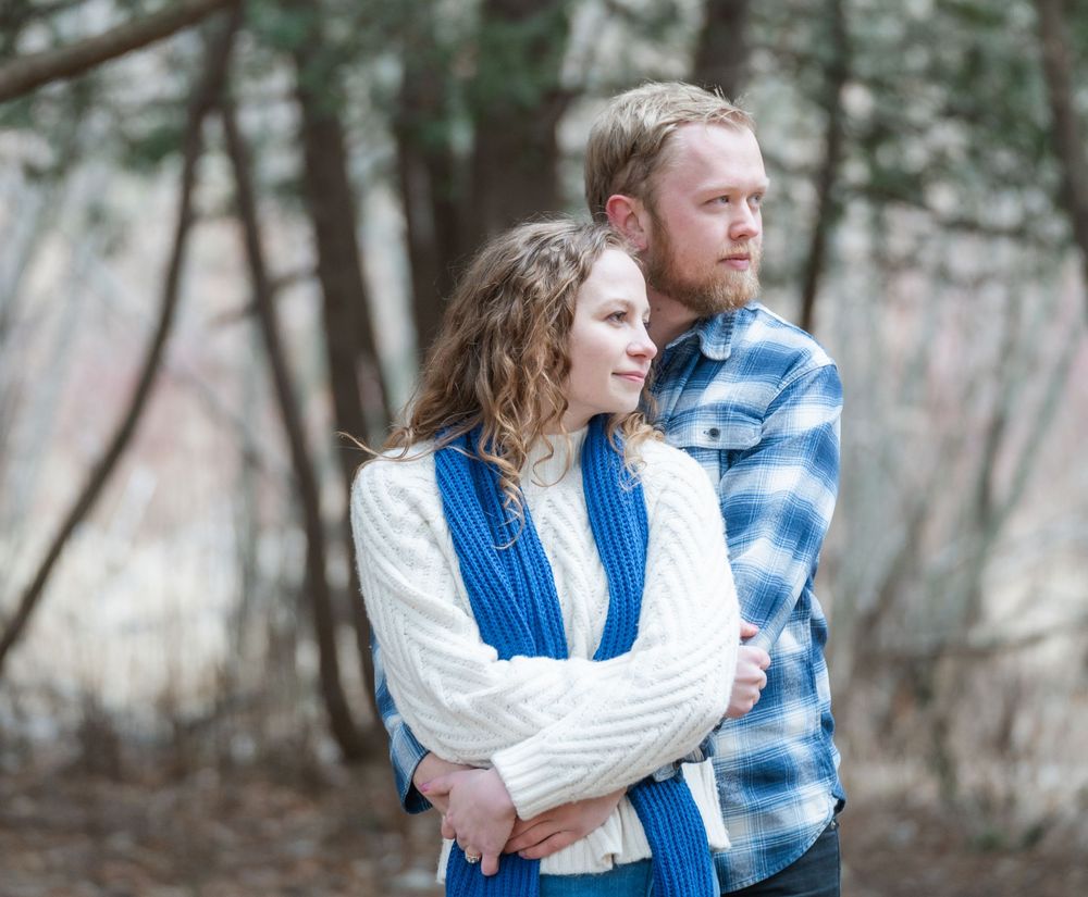 Romantic embrace framed by bare trees and golden March light at the Landscape Arboretum