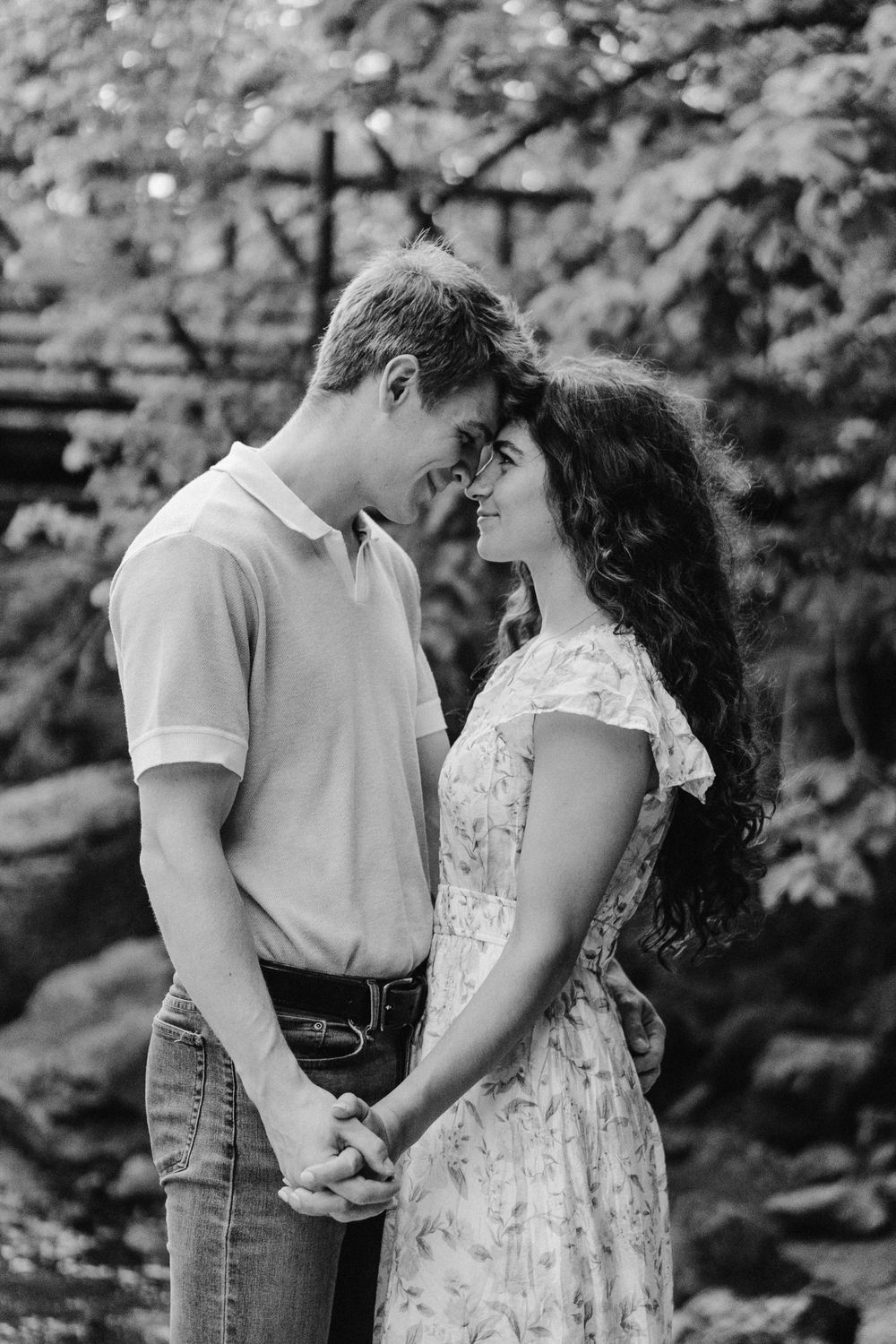 Silhouetted engagement portrait with forest backdrop and waterfall mist at Willow River in Hudson