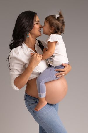 A tender moment shared between parent and child against a gray studio backdrop in a series of movement captures.